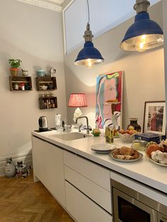 a kitchen with two blue lights hanging over the counter