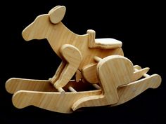 a wooden toy rocking horse on a black background