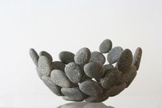 a bowl made out of rocks sitting on top of a table