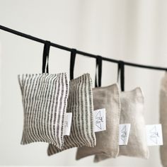 four pillows hanging on a clothes line with tags attached to the strings that hold them