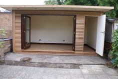 an outdoor room with wooden walls and doors