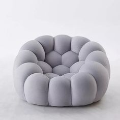 a round chair made out of mesh on a white surface with no one around it