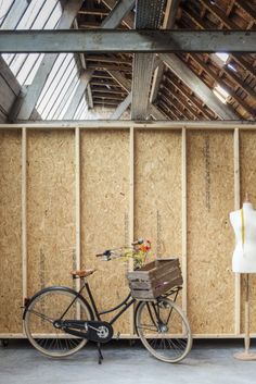 a bike parked next to a wooden wall in a room filled with wood planks