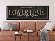 a couch and table in a room with a sign above it that says the smith's lower level where the fun happens