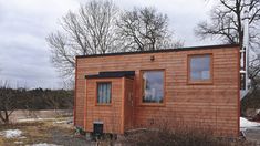 a small wooden cabin sitting on top of a snow covered field