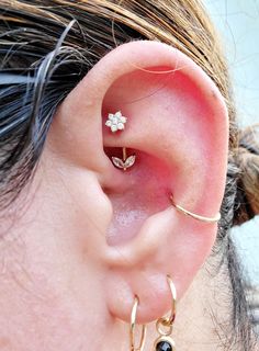 a close up of a person's ear with two different types of piercings