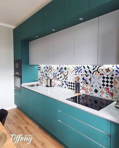 a kitchen with green cabinets and white counter tops