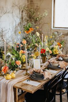 the table is set with flowers and candles