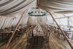 the inside of a tent with tables and chairs