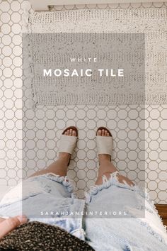 a person with their feet up on a bed in front of a mosaic tile wall