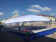 an inflatable boat is on the ground near some buildings and blue tarps