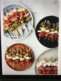 three plates with skewered meats and vegetables on them, one has cheese