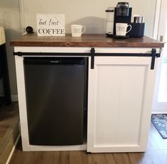 a black dishwasher sitting on top of a wooden counter next to a coffee maker