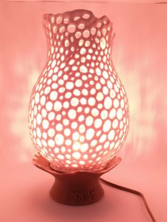 a light that is sitting on top of a table next to a pink wall and floor