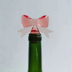 a green glass bottle with a pink bow on it's top and the bottom is empty