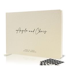 an open book with black and white checkered paper on the cover, next to two matching coasters