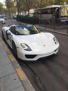 a white sports car is parked on the side of the road