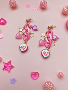 "Pink Hi Charm Chain Earrings Think pink and let these maximalist, extroverted earrings say \"Hi\" for you. They're bold, bright, and filled with fun little charms, including pink pastel chains, gold stars, and shimmery pink hearts. A sweet birthday gift for your outgoing friend, or the perfect pair to keep for yourself. Included are bullet-clutch backs for added comfort while wearing.  Measurements: approximately 2.5 inches from post to end Materials: lightweight plastic chain, gold plated meta Freya Goddess, Maximalist Aesthetic, Pink Chain, Kawaii Crafts, Pink Charm, Sweet Birthday, Think Pink, Metal Charms, Charm Chain