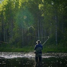 a man standing in the water with a fishing rod