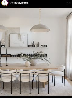 the dining room table is surrounded by white chairs