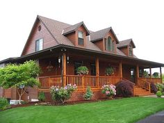 a large wooden house sitting on top of a lush green field