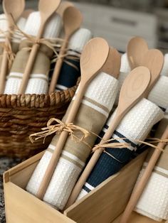 several wooden spoons are in a basket on the floor next to some napkins