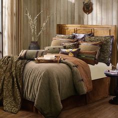 a bedroom with wood paneled walls and bedding in the center, along with a wooden headboard