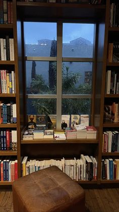 a book shelf filled with lots of books next to a window covered in windowsills