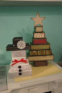 a snowman made out of books sitting on top of a white dresser next to a christmas tree