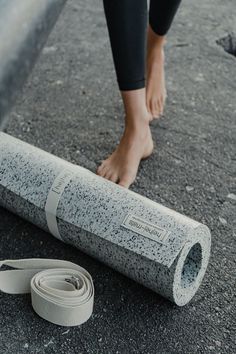 a person standing next to a rolled up yoga mat