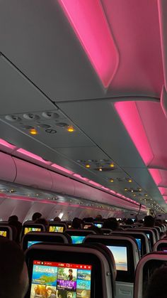 the interior of an airplane with pink lighting