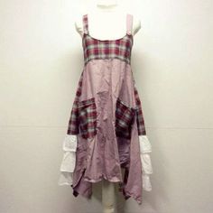 a white mannequin wearing a pink dress with plaid print on the front and back