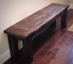 a wooden bench sitting on top of a hard wood floor