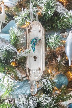 a christmas tree with ornaments on it and an old fashioned key hanging from the top