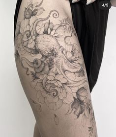 a woman's thigh with an octopus and flowers tattoo on it