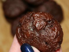 a person holding a chocolate cookie in their hand