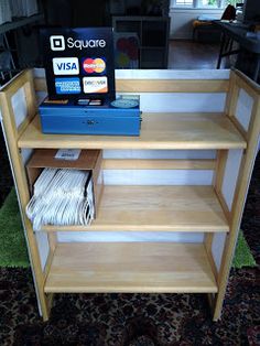 there is a shelf that has some books on it and magazines in front of it