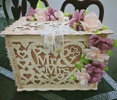 a wedding cake in the shape of a trunk with flowers on it and an mr & mrs cutout