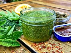 a jar filled with pesto next to other ingredients