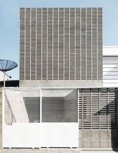 a building with a satellite dish on top of it next to a fenced in area