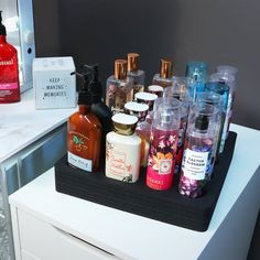 an assortment of bath and body care products on a black tray in front of a mirror