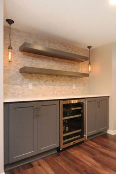 an empty kitchen with stainless steel appliances and wood flooring