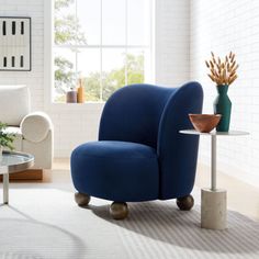 a living room with white walls and blue chairs