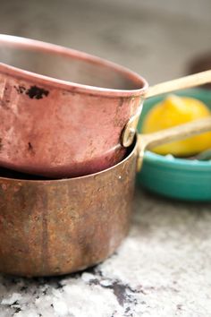 two copper pots sitting next to each other on a table