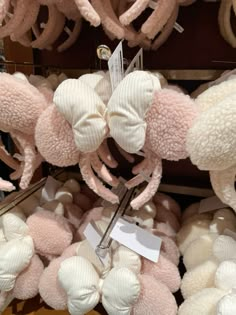 several pink and white stuffed animals are on display in a store with tags attached to them