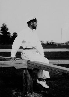 a black and white photo of a man sitting on a bench