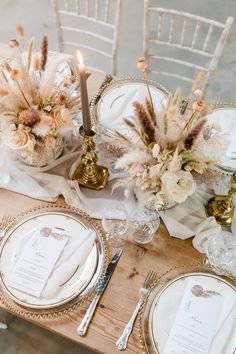 the table is set with white and gold place settings