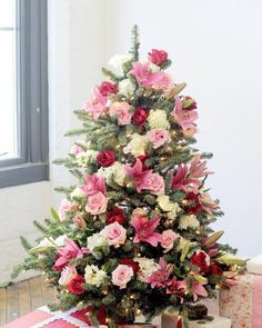 a small christmas tree with pink and white flowers