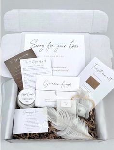 an open box filled with lots of items like feathers, cards, and envelopes