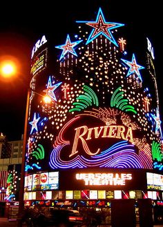 the riviera theatre lit up at night with fireworks and stars on it's side